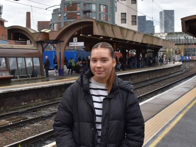 Women smiling at camera at a train station