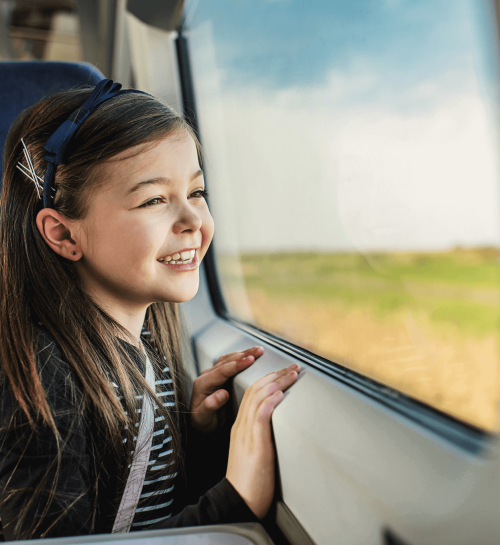 Young passenger looking out a train window