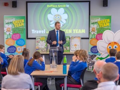 A man in a suit presents to children at a school